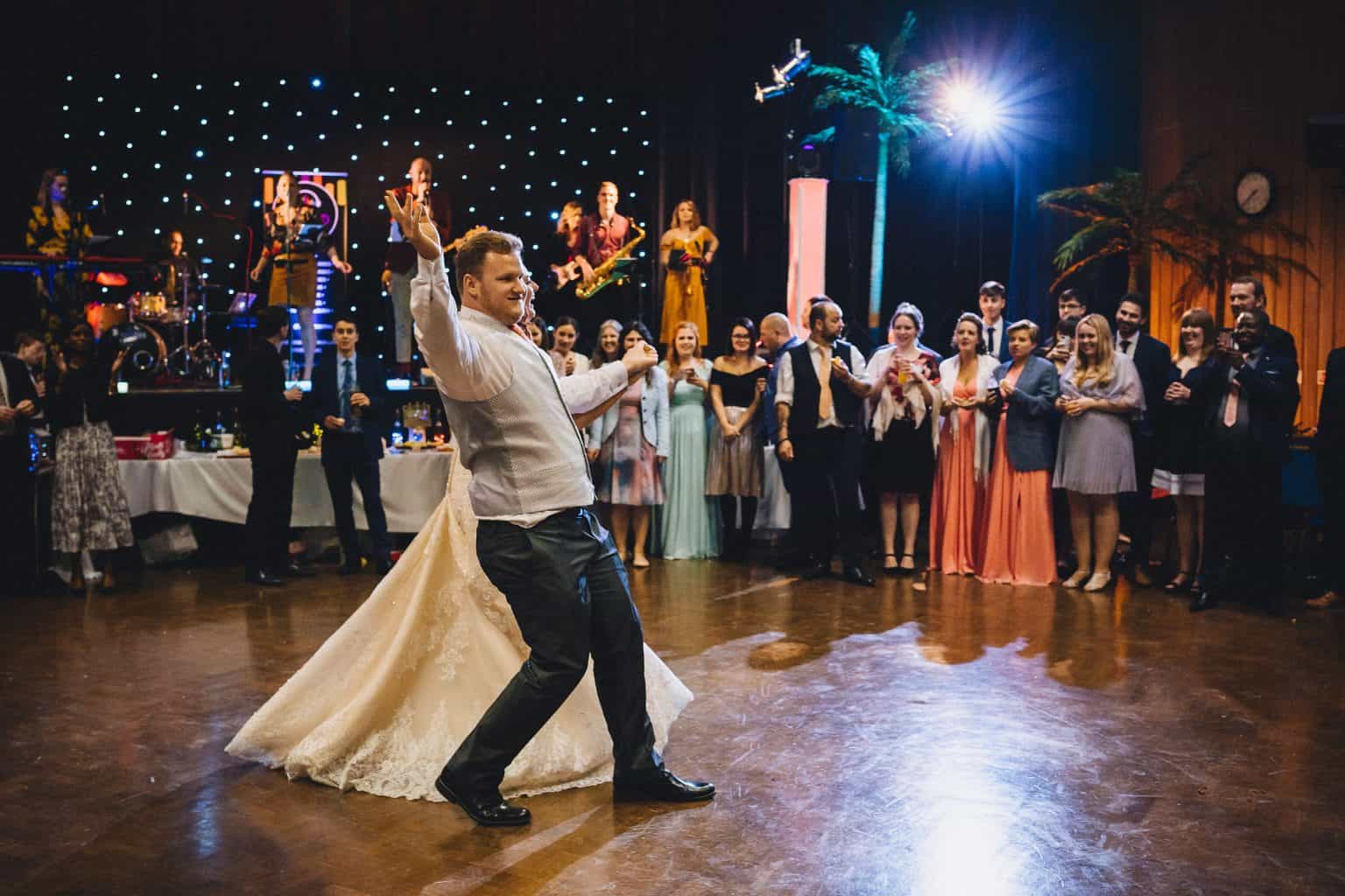 A live band performing under warm lights at a wedding reception, guests dancing