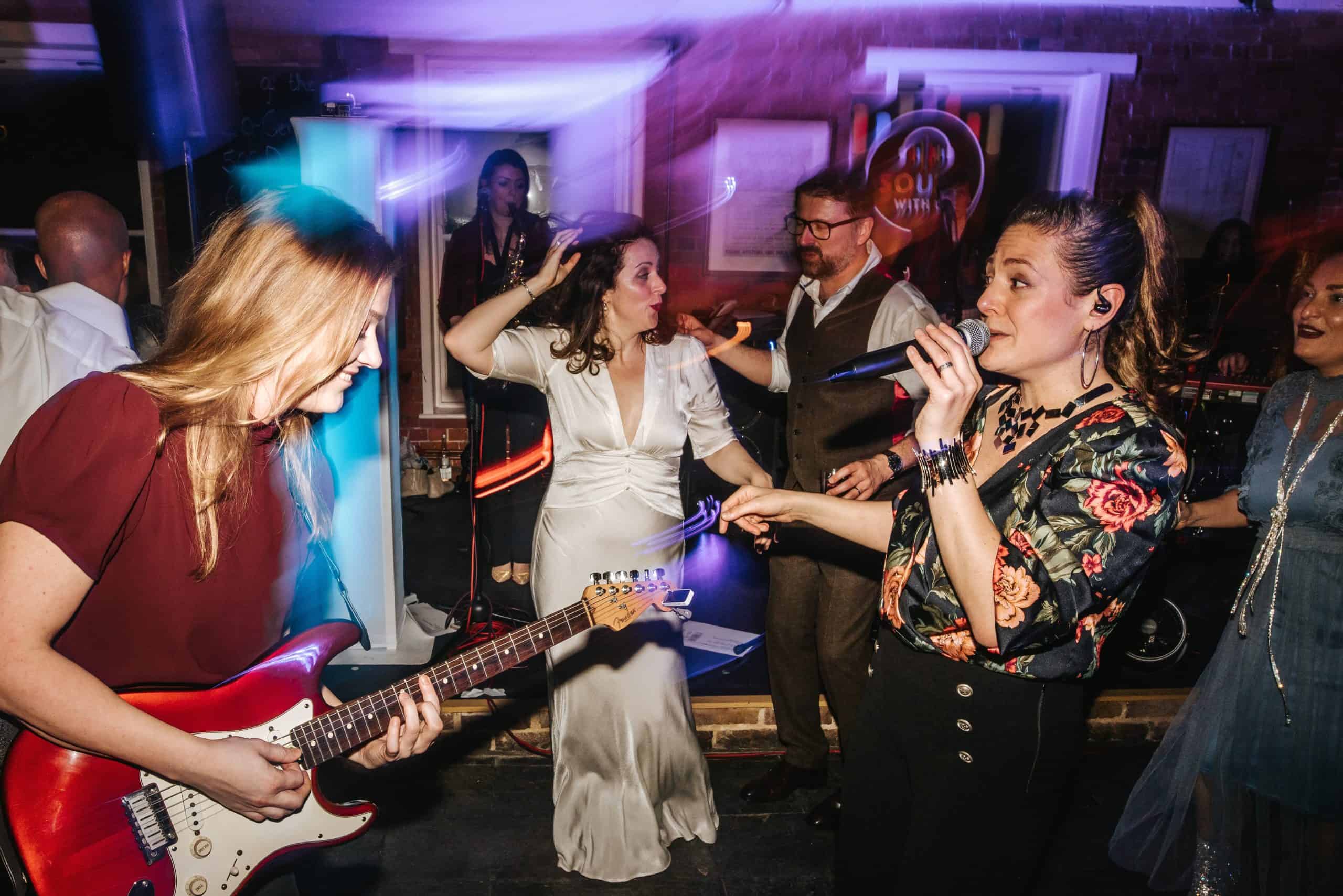 Guests dancing with hands raised as the band plays